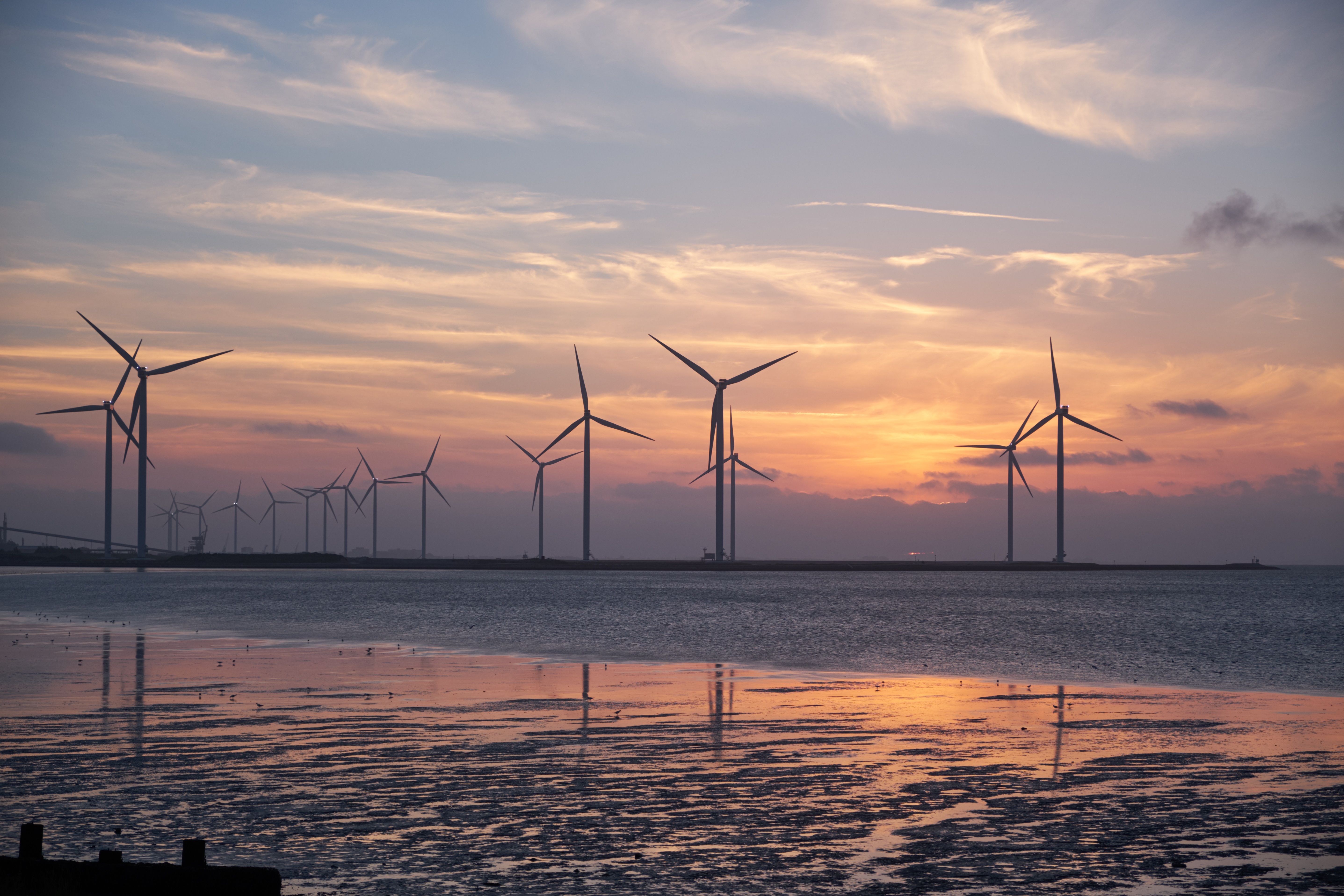 Turbine eoliche al tramonto, energia rinnovabile da immagazzinare